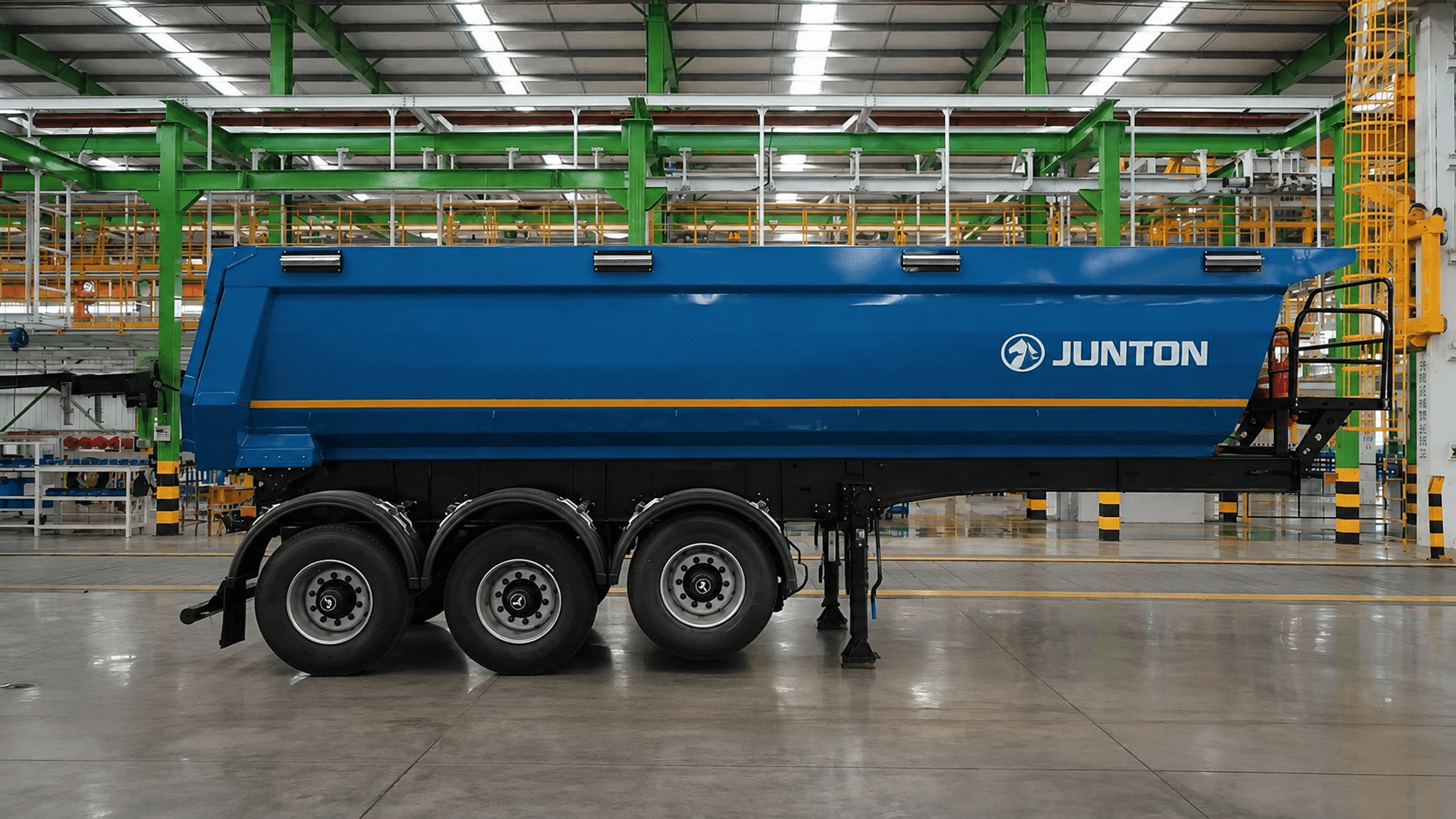 Semirremolque Junton azul (tolva volquete) en planta de fábrica, vista de perfil